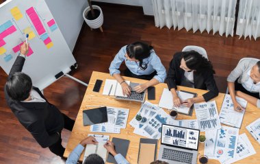 Toplantı masasındaki finansal veri raporlarını analiz eden çeşitli iş analist gruplarının geniş görüşü. İş zekası analizine göre çizelge ve grafik paneli. Çok titiz.