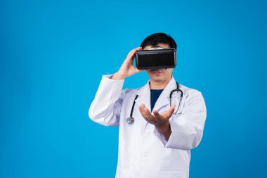 VR kulaklık takan zeki doktor analitik tıp araştırmaları içeren verileri birleştirmeye çalışıyor. Mavi arka plan fütüristik teknoloji hologramı sanal gerçeklik meta dünyası. Entrika.