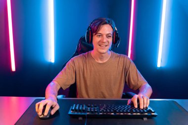 Kazanmak için çevrimiçi oyun oynayan akıllı flama makinesinin sunucu kanalı, neon ışıklı odada seçilen takım yarışması için izleyicilerle birlikte canlı yayında canlı yayında kulaklık takıyor. Bireysel.