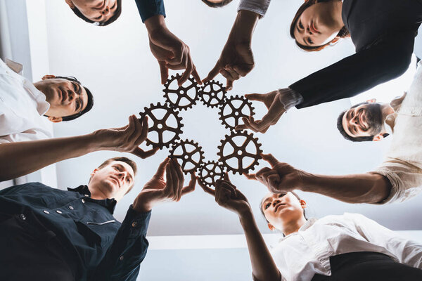Business team joining cogwheel in circular together symbolize successful group of business partnership and strong collective unity teamwork in community workplace with productive efficiency. Prudent