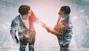 İş adamlarının arka plandaki belediye binasında el sıkışması ortaklık anlaşmasının başarısını gösteriyor. Kurumsal takım çalışması, güven ortağı ve iş anlaşması kavramı. uds