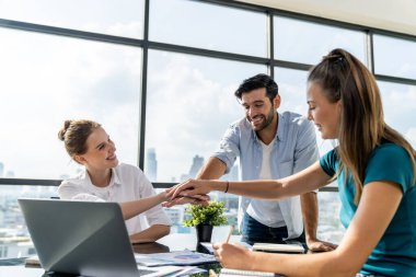 Bir grup yetenekli iş adamı modern ofiste el ele tutuşuyor. Mutlu akıllı iş adamları birlikte çalışıyor. Birleşmeyi, aşkı, takımı, birlikte çalışmayı, ortaklığı, iş yerini temsil etti. İzleme.