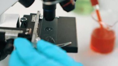 Bilimsel laboratuar araştırmacısı mikroskobik slayta kan örneği bırakır. Tıbbi muayene için ya da yeni teşhis aleti için. Mikrobiyolog, tıp çalışanı laboratuarda deney yapıyor. Ağır çekim. Katı.