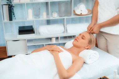 Kafkasyalı kadın stres önleyici kafa masajından ve lüks tatil beldesi ya da otel spa salonundaki modern ışık ortamında yüz güzelliği eğlencelerini şımartmaktan hoşlanıyor. Sessiz.