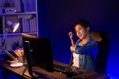 Genç ve güzel Asyalı iş kadını, gece vakti neon ışığı modern ofisinde aşırı çalışma raporunu bitirdikten sonra kas gevşemesi için ağrılı vücudunu esnetmeye ara veriyor. Taktik.