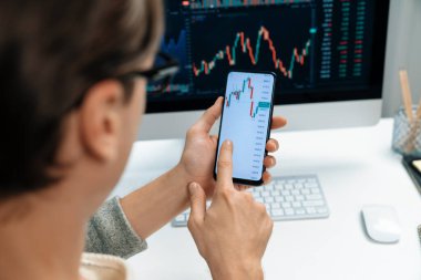 Akıllı borsa yatırımcıları ekranda akıllı telefon ile piyasa borsasını işaret ederek dizüstü bilgisayarın yanı sıra en yüksek dinamik yatırım oranını göstererek, modern işyerindeki veri planlamasına odaklanıyorlar. Bireysel.