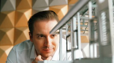 İnşaat yapısını ve hata noktalarını incelerken profesyonel mühendis yüzünün ev modeline bakması. Yetenekli proje yöneticisi ev modelini kontrol ediyor. İş tasarımı konsepti. Yönlendirici.