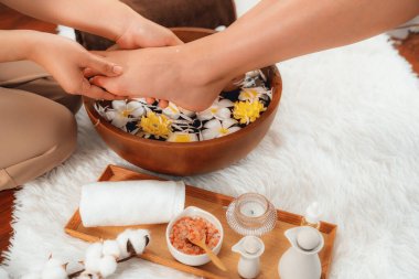 Kadınlar lüks spa salonlarında keyifli ayak masajlarına devam ederken, masör de hafif gün ışığı atmosferinde refleksoloji terapisi veya otel ayak spa 'sında. Sessiz.