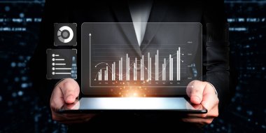 İş adamı, tahmin edilen büyük veri modellerinden gerçek zamanlı analizlere uzanan eğilimleri ve görüşleri ortaya çıkarmak için veri analizlerini derinlemesine inceleyerek, veri güdümlü kararların analitik endüstrileri nasıl ileri götürdüğünü öğrenir Faas