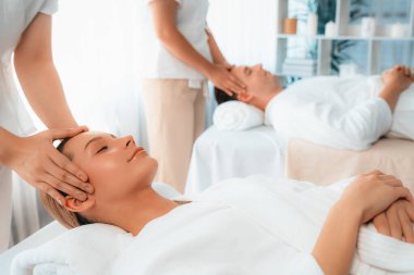 Kafkasyalı çift stres önleyici kafa masajının keyfini çıkarıyor ve lüks otellerde ya da otel spa salonlarında gündüz kaplıcalarında yüz güzelliği eğlencelerini şımartıyor. Sessiz.