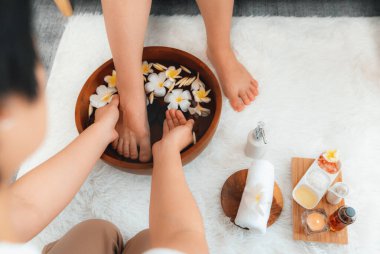 Kadınlar lüks spa salonlarında keyifli ayak masajlarına devam ederken, masör de hafif gün ışığı atmosferinde refleksoloji terapisi veya otel ayak spa 'sında. Sessiz.