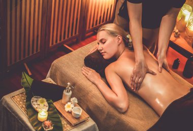 Beyaz kadın müşteri stres önleyici spa masajının keyfini çıkarıyor ve lüks otel ya da otelde sıcak mum ışığında güzellik teniyle eğleniyor. Sessiz.