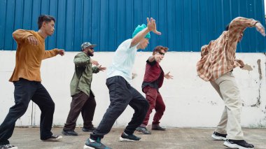 Bir grup hip hop koreografı duvarda sokak dansı yapıyor. Break dans pratiği yapan genç break dansçı, modern ritme ayak uyduran, canlı hissetmeyi ifade eden. Açık hava 2024. Hiphop.