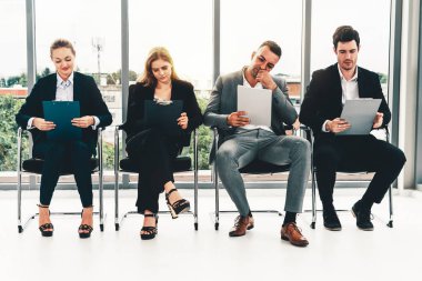 İş kadınları ve iş adamları iş görüşmesi için koltuklarda beklerken CV dosyasına devam ediyorlar. Şirket işi ve insan kaynakları kavramı. uds
