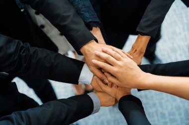 Birçok mutlu iş adamı neşe ve başarıyla el ele tutuşuyor. Şirket çalışanı başarılı bir iş projesini bitirdikten sonra kutlama yapıyor. Şirket ortaklığı ve başarı kavramı. uds