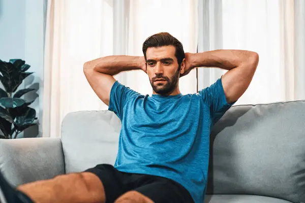 stock image Athletic body and active sporty man using furniture for effective targeting muscle gain exercise at gaiety home exercise as concept of healthy fit body home workout lifestyle.