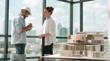 Ev modelinin yanında duran yetenekli mimar mühendis takımı tartışması. Bir grup zeki iç mimar not alıyor ve paylaşıyor, beyin fırtınası yapıyor, bina tasarımı hakkında düşünüyor. İzleme