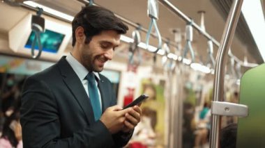 Zeki iş adamı trende dururken terfi aldığı için kutlama yapıyor. Beyaz erkek işçi, müdürle başarılı proje ve satışların artması hakkında iyi haberler aldı. Sevinçli..