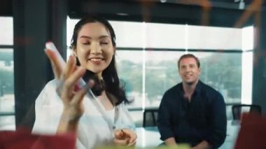 Genç kendine güvenen iş kadını projeyi uzman yatırımcıya sundu. Profesyonel proje yöneticisi başlangıç projesini açıklamak için yapışkan notlar kullanır, beyin fırtınası fikirlerini yatırımcıya paylaşır. Yönlendirici.