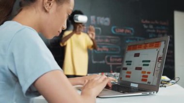 VR kullanan Afrikalı öğrenci meta-dünya ile etkileşime girerken liseli kız el kodlama programını kapat. Zeki çocuk sanal gerçeklik gözlüğü takıyor ve yenilikçi sınıfta video oyunları oynuyor. Öğretim