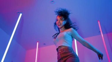 Latin dansçıların kameraya bakıp şehrin pop müziğiyle dans ettiği düşük açılı kamera. Profesyonel çekici hipster, mor veya neon ışıklı hip hop şarkısına geçiyor. Şık bir kumaş. Mutluluk.