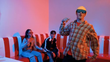 Kafkasyalı break dansçı çeşitli arkadaşlar birlikte dans ederken hareket eder. Çok kültürlü grup arkadaşını desteklemek ve cesaretlendirmek için el sallarken mutlu hipster hareketi. Mutluluk.