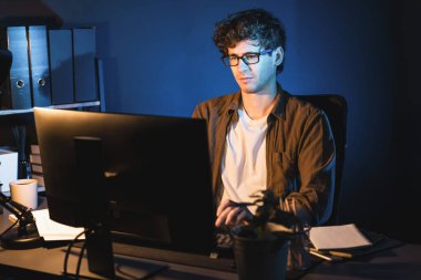 Genç işadamı, Neon Light Modern Ofis 'te yaratıcı bir başlangıç projesi için bilgisayara odaklanıyor. Düşünüyorum da, pazarlama ağı yaratıcıdan pazar kanalı tasarım konseptine çevrimiçi planlama. Toplayıcı.