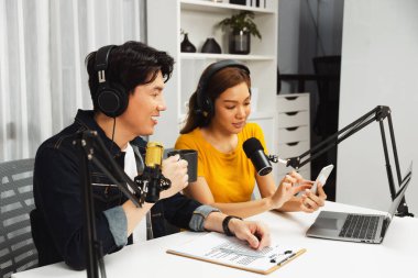 Gülümseyen radyo etkili sunucular, kulaklık takıp sosyal medyayı canlı yayında dinleyicilere telefon ve dizüstü bilgisayarla canlı yayınlıyorlar. İnfobahn.