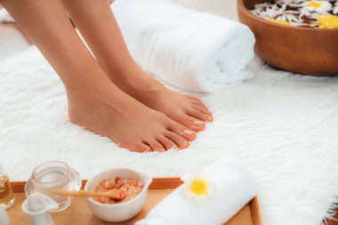 Panorama üstteki kadın lüks spa salonunda mutlu bir ayak masajı yaparken, masör de hafif gündüz atmosfer tesisinde veya otel ayak spasında refleksoloji terapisi uyguluyor. Sessiz.