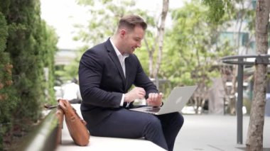 Kafkasyalı iş adamları laptopta çalışırken saati kullanarak toplantıyı hatırlatıyorlar. Proje yöneticisi, uzaktan kumandalı iş ekibiyle çalışırken bilgisayar yazma raporunu kullanıyor. Urbane.