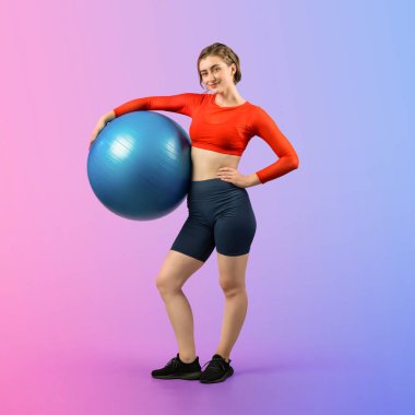 Vücut uzunluğunun tamamı atletik ve sportif genç bir bayanın izole edilmiş arka planda duran bir duruşta topa egzersiz yapmasıyla geçiyor. Sağlıklı aktif ve vücut bakımı yaşam tarzı.