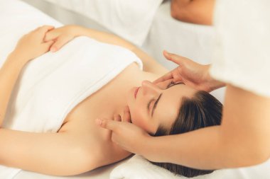 Kafkasyalı kadın stres önleyici kafa masajından ve lüks tatil beldesi ya da otel spa salonundaki modern ışık ortamında yüz güzelliği eğlencelerini şımartmaktan hoşlanıyor. Sessiz.