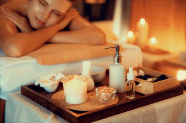 Aromaterapi masajı ambiyansı ya da spa salonu kompozisyon düzeneği bulanık kadınlara odaklı dekor mumları ve spa aksesuarları ile tatil köyü veya otel arka planında keyifli aroma spa masajı yapan. Sessiz.