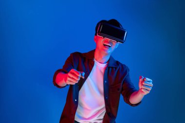 VR kullanan zeki bir oyuncu araba yarışlarında araba sürerken yeni dünyaya dönüyor mavi neon ışıklı duvar bağlantılı fütüristik teknoloji sanal gerçeklik meta 'sını izole ediyor. Entrika.