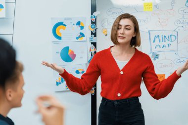 Profesyonel çekici kadın lider, modern iş toplantı odasında beyin fırtınası zihin haritalama istatistikleri ve renkli yapışkan notlar kullanarak yaratıcı pazarlama planını sunuyor. Tertemiz..