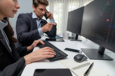 Borsacı bir adam, borsada yüksek kâr elde etme noktasını dijital para birimiyle bildirmek için tüccar işadamını ararken, bir kadın da gerçek zamanlı olarak veri monitörünü incelemeye başladı. Varsayım.