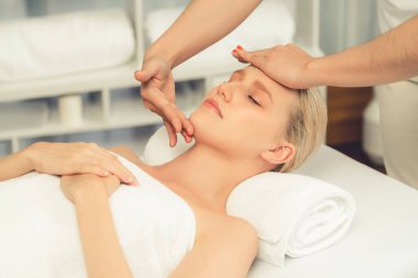 Kafkasyalı kadın stres önleyici kafa masajından ve lüks tatil beldesi ya da otel spa salonundaki modern ışık ortamında yüz güzelliği eğlencelerini şımartmaktan hoşlanıyor. Sessiz.