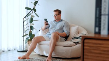 Orta yaşlı bir adam, iş için telefon arama verilerini kullanarak, çocukları iyi bir yetişkin ya da eğlence olsun diye odada kahve fincanıyla koltukta oturur. İşadamı teknolojiyi kolaylık için kullanır. Uyumsuzluk.