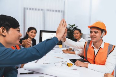 Çeşitli inşaat mühendisi ve müvekkil grupları, mimari proje üzerinde başarılı bir anlaşma yaptıktan, inşaat planını gözden geçirdikten ve toplantı masasında plan oluşturduktan sonra kutlama ve beşlik çakışma yaptılar.