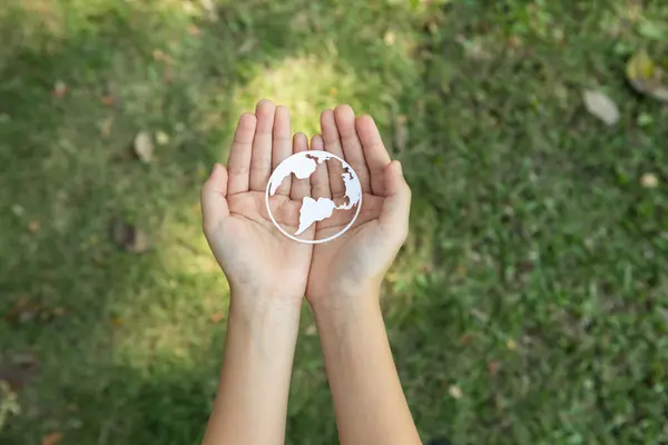 stock image Top view hand holding Earth planet icon symbolize eco-friendly commitment to environmental protection and zero carbon emission. Earth World Day concept to promote eco awareness. Gyre