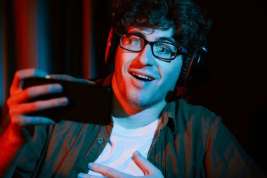 Stresli genç oyun flaması takımı akıllı telefondan Esport 'la oynuyor. Daha sert oyun seviyesinde, neon ışıklı odada kazanmanın utancı ve şaşkınlığı ile mücadele ediyorlar. Strateji planı uyguluyorum. Toplayıcı.