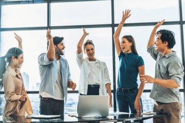 Mutlu çok ırklı iş adamları oy vermek ve cevap vermek için el kaldırdı. Bir grup farklı iş adamı şehir ve gökdelenle pencerenin yanında dururken birlikte çalışıyorlar. İzleme.