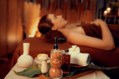 Aromaterapi masajı ambiyansı ya da spa salonu kompozisyon düzeneği bulanık kadınlara odaklı dekor mumları ve spa aksesuarları ile tatil köyü veya otel arka planında keyifli aroma spa masajı yapan. Sessiz.