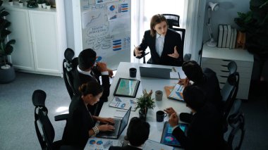 Akıllı yönetici projesinin üst görünümü beyaz tahtaya zihin haritası ve finansal grafik ile işaret ediyor ve çeşitli yatırımcılar hisse yatırım grafiğini dinleyip analiz ederken pazarlama fikrini açıklıyor. Müdürlük.