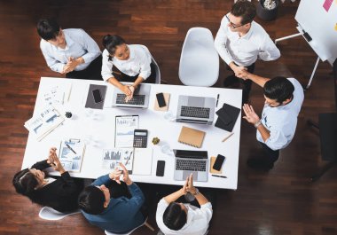 Üst düzey ofis çalışanları stratejik iş pazarlama toplantısı üzerine anlaşma yaptıktan sonra el sıkışıyor. Takım çalışması ve olumlu tutum verimli ve destekleyici bir iş yeri yaratır. Tedbirli