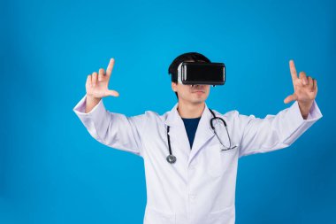 VR kulaklık takan zeki bir doktor metaevren seçerek tıbbın detaylarına yakınlaştırıyor mavi arka plan fütüristik teknoloji hologramı sanal gerçeklik zeki meta dünya. Entrika.