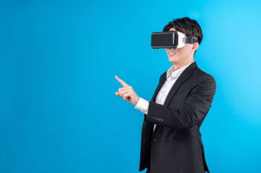 Asyalı işadamı, sanal gerçeklik mavi telif uzayı yenilik teknolojisini analiz eden gelecekçi metaevrendeki iş dünyası raporuna dokunarak ekranı titizlikle inceliyor. Entrika.