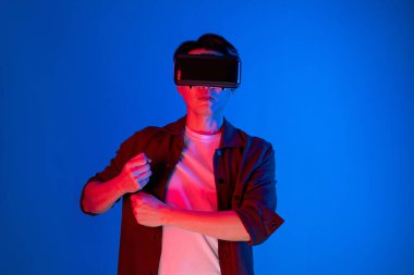 VR gözlük takan akıllı bir oyuncu golf kursu hologramı, metaevren dünyasındaki dijital fütüristik teknolojiyi birbirine bağlayan açık mavi ekranı izole etti. Entrika.