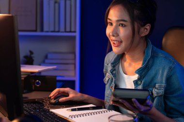 Başarılı genç, güzel Asyalı yaratıcı hesaplama rakamı. Sosyal medyadaki satış hedefi raporundan elde edilen kazanç. Neon ışığı gecesinde yeni bir strateji planlamak için serbest meslek sahibi olmak. Taktik.