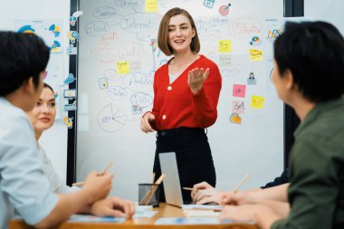 Profesyonel çekici kadın lider, modern iş toplantı odasında beyin fırtınası zihin haritalama istatistikleri ve renkli yapışkan notlar kullanarak yaratıcı pazarlama planını sunuyor. Tertemiz..